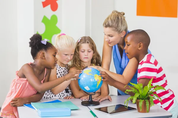 Lehrerin diskutiert Globus mit Kindern — Stockfoto