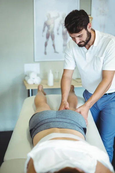 Sjukgymnasten ger ben massage till en kvinna — Stockfoto