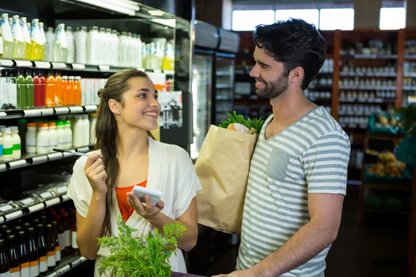 Pareja de control de bloc de notas durante las compras —  Fotos de Stock