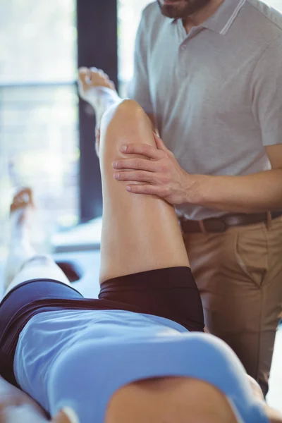 Fisioterapeuta dando masaje de piernas a una mujer —  Fotos de Stock