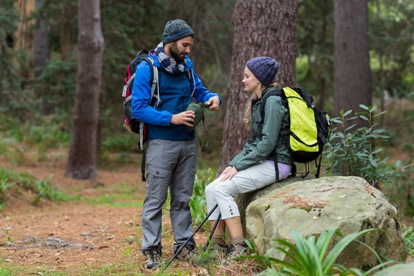 Pareja excursionista interactuando entre sí en el bosque — Foto de Stock