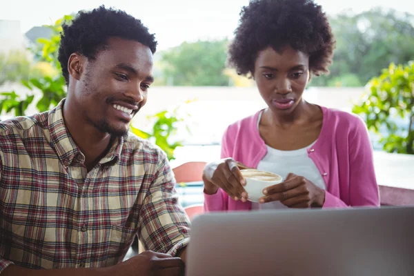 Pareja joven usando laptop en cafetería — Foto de Stock