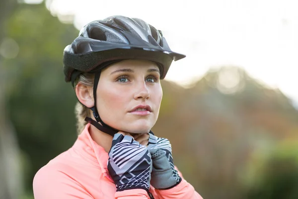 Atlético feminino usando capacete de bicicleta — Fotografia de Stock