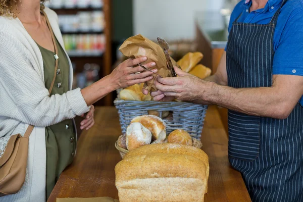 Seção intermediária de mulher comprando pão na padaria — Fotografia de Stock