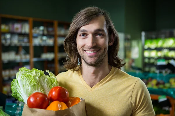 Seorang pria memegang sekantong sayuran — Stok Foto