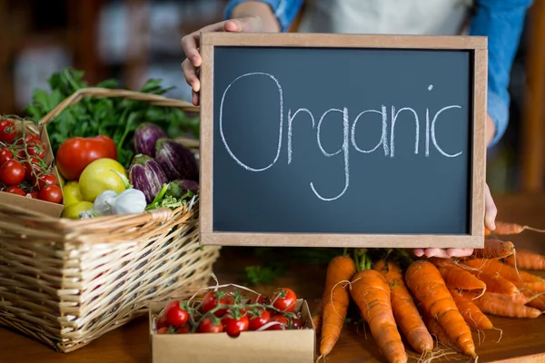 Ženské zaměstnanci, kteří zastávají organických vývěsní štít — Stock fotografie