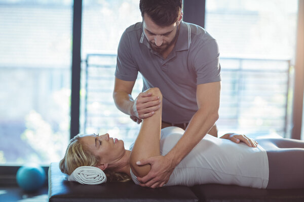 Physiotherapist giving shoulder therapy to a woman Royalty Free Stock Photos