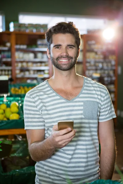 Hombre usando su teléfono en la sección orgánica — Foto de Stock