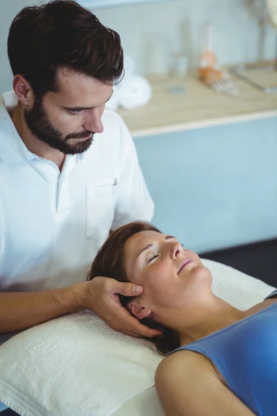 Fisioterapeuta dando masaje en la cabeza a una mujer —  Fotos de Stock