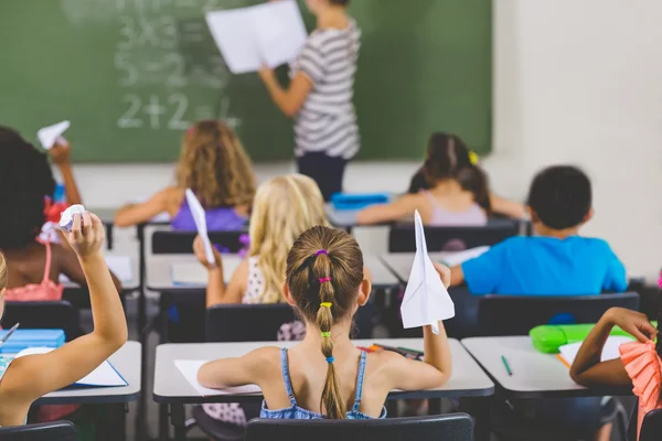 Escolares con aviones de papel en el aula — Foto de Stock