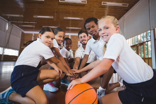 Учитель спорта и школьники формируют стопку рук — стоковое фото