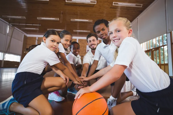 Sportlehrer und Schüler bilden Handstapel — Stockfoto