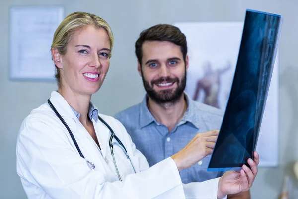 Physiotherapist showing x-ray to a patient — Stock Photo, Image