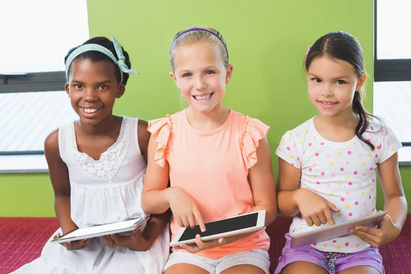 Schülerinnen nutzen digitales Tablet in Bibliothek — Stockfoto