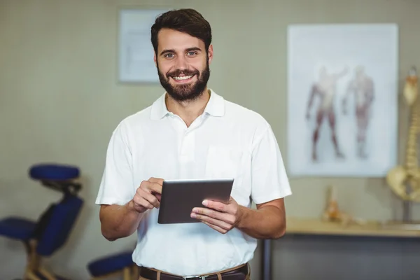 Mannelijke therapeut holding digitale tablet in kliniek — Stockfoto