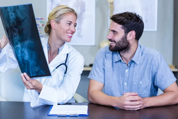Physiotherapist showing x-ray to a patient — Stock Photo, Image