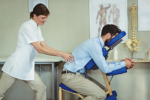 Physiotherapeut gibt einer Patientin Rückenmassage — Stockfoto