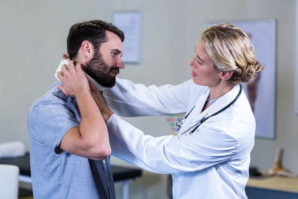 Physiothérapeute examinant le cou du patient — Photo