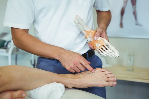 Fisioterapeuta explicando modelo de pés para o paciente — Fotografia de Stock