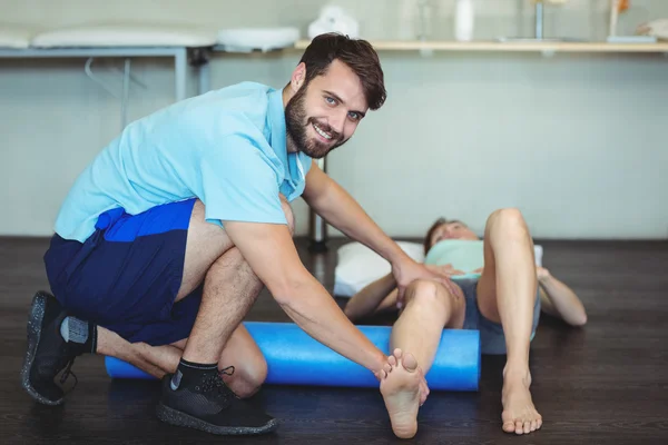 Physiotherapist doing leg therapy to a woman — Stock Photo, Image