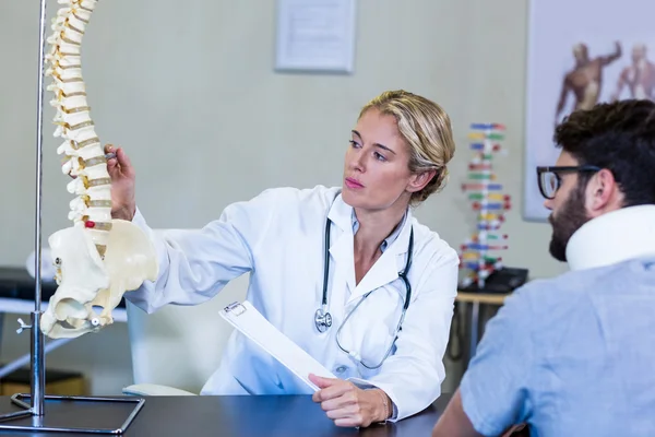Physiotherapist explaining the spine model to patient — Stock Photo, Image