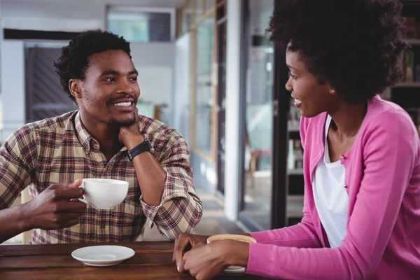 Pareja joven interactuando entre sí en la cafetería — Foto de Stock