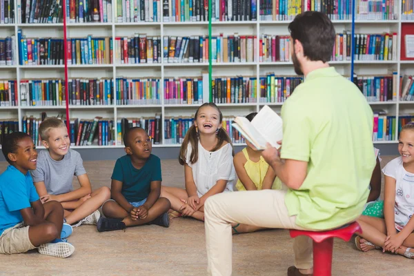 Insegnante che insegna ai bambini in biblioteca — Foto Stock