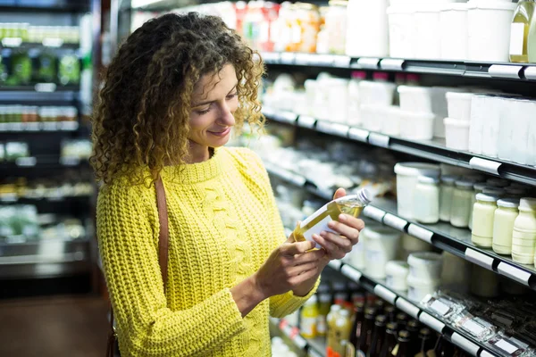 Mujer seleccionando una botella de aceite — Foto de Stock