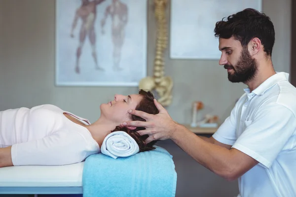 Fisioterapeuta dando masaje en la cabeza a una mujer —  Fotos de Stock