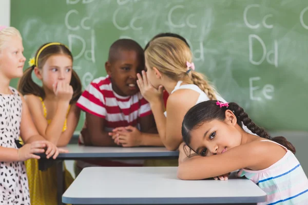 Portrait of schoolgirl lying on desk in classroom — Stock Photo, Image