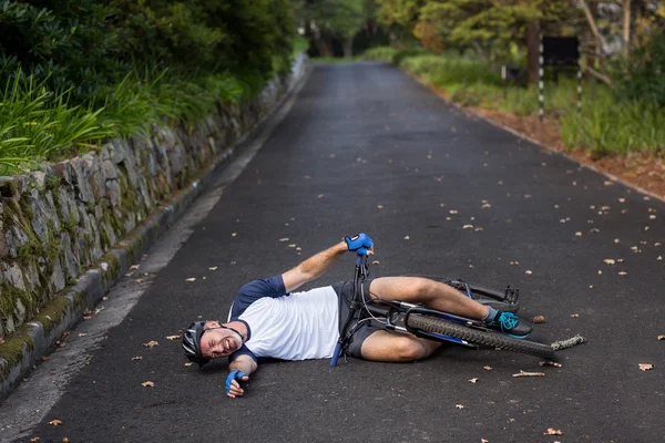 Masculino ciclista caiu de sua bicicleta de montanha — Fotografia de Stock
