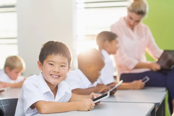 Crianças da escola usando telefone celular em sala de aula — Fotografia de Stock