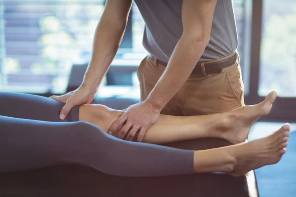 Fisioterapeuta dando terapia de rodilla a una mujer —  Fotos de Stock