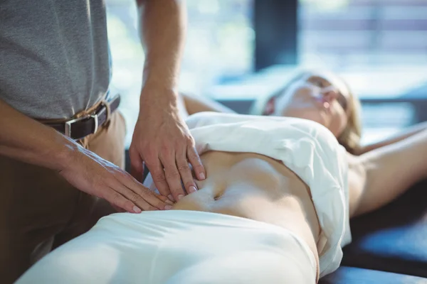 Fisioterapista che fa un massaggio allo stomaco a una donna — Foto Stock