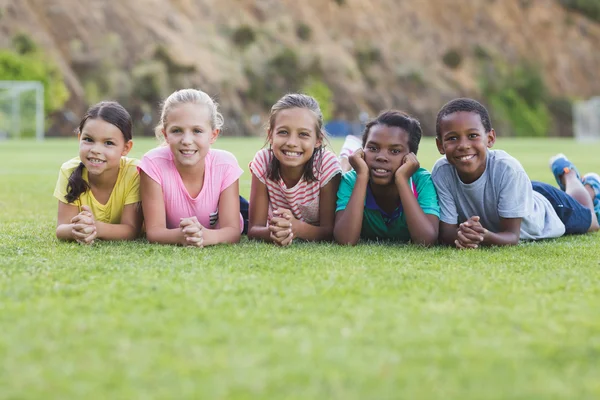 Schoolkinderen liggen op speelplaats — Stockfoto