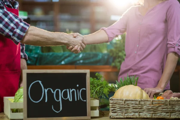 Staff shaking hand with woman in organic section — Stock Photo, Image