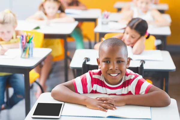 Funktionshindrade skolpojke leende i klassrummet — Stockfoto