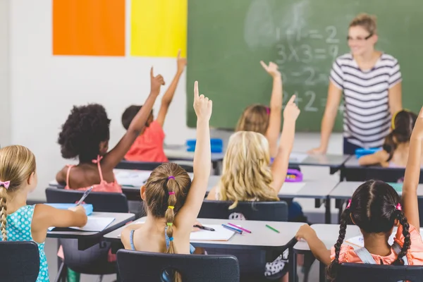 Des écoliers lèvent la main en classe — Photo