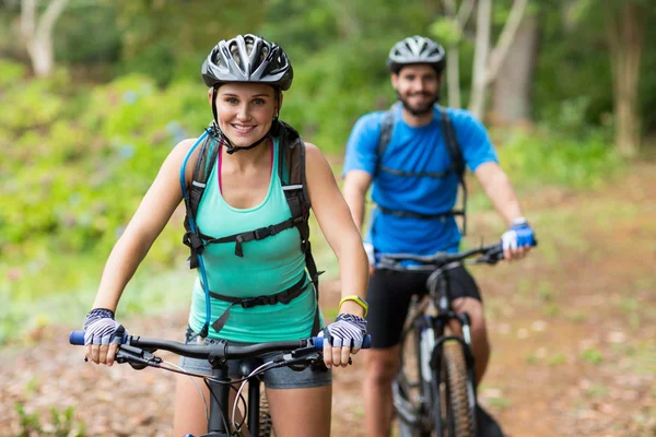 Athletic couple cycling in forest — Stock Photo, Image