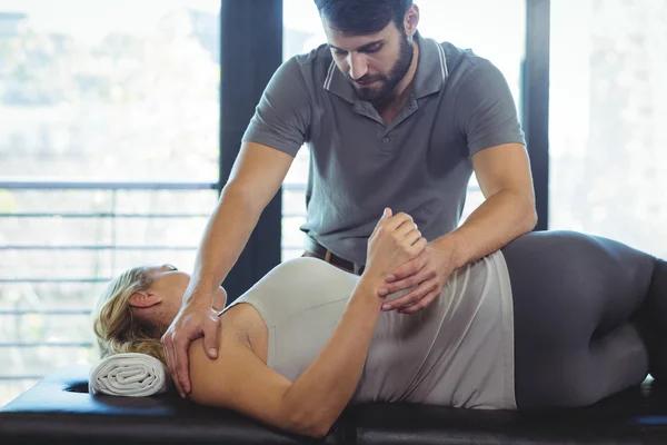 Physiotherapist giving shoulder therapy to a woman — Stock Photo, Image