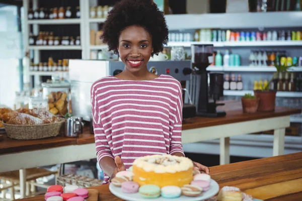 Smiling woman standing at counter in cafe — Stock Photo, Image