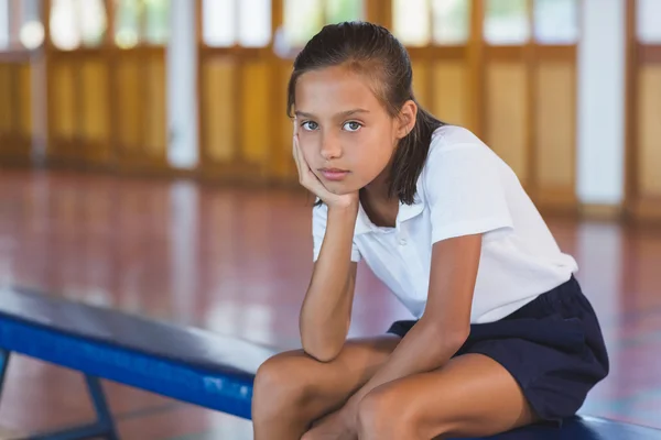 Portret van schoolmeisje zit in basketbalveld — Stockfoto