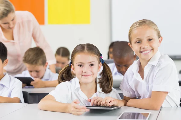 Crianças da escola usando tablet digital em sala de aula — Fotografia de Stock