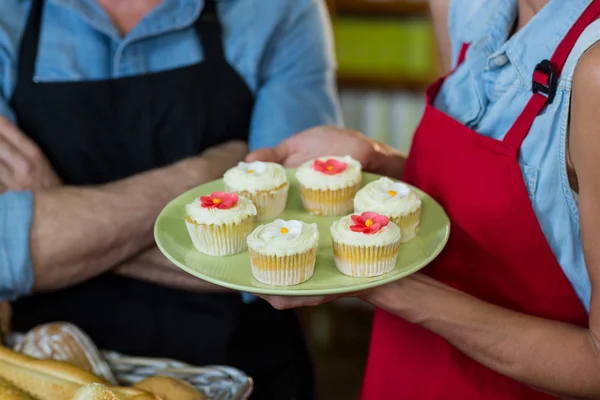 Sezione centrale del personale femminile con un piatto di cupcake — Foto Stock