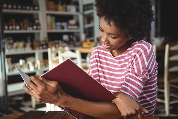 Mujer sonriente leyendo menú en la cafetería —  Fotos de Stock