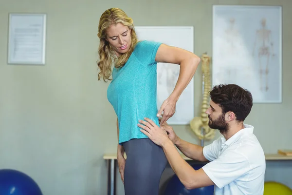 Fysiotherapeut onderzoekt dames terug — Stockfoto