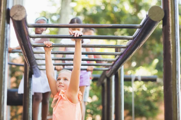 Schoolgirl hanging on monkey rack — Stock Photo, Image