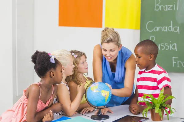 Lehrerin diskutiert Globus mit Kindern — Stockfoto