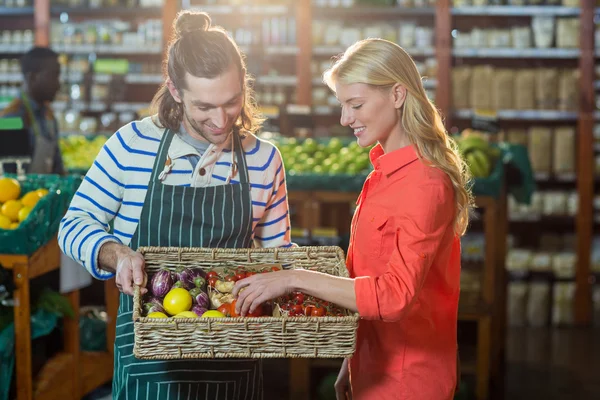 Mujer seleccionando verduras frescas de la cesta — Foto de Stock