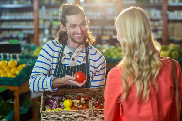 Personal masculino ayudando a la mujer en la selección de verduras frescas — Foto de Stock